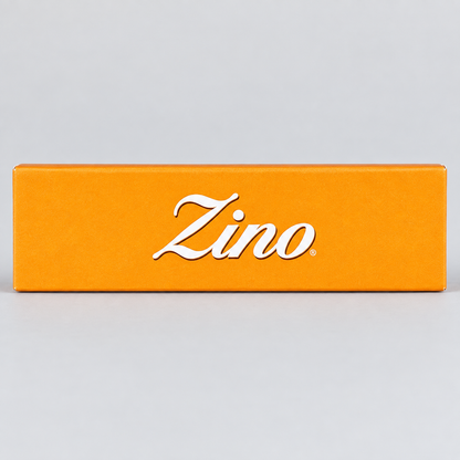 A bright orange rectangular box with the brand name 'Zino' in white cursive script, photographed against a light gray background.