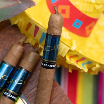 Cigars with blue and black labels in front of a colorful pinata.