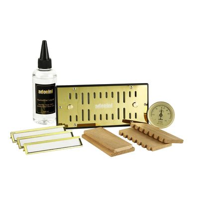 Set of Adonai products including a bottle, gold metal sheet, wooden blocks, and a gauge on a white background.