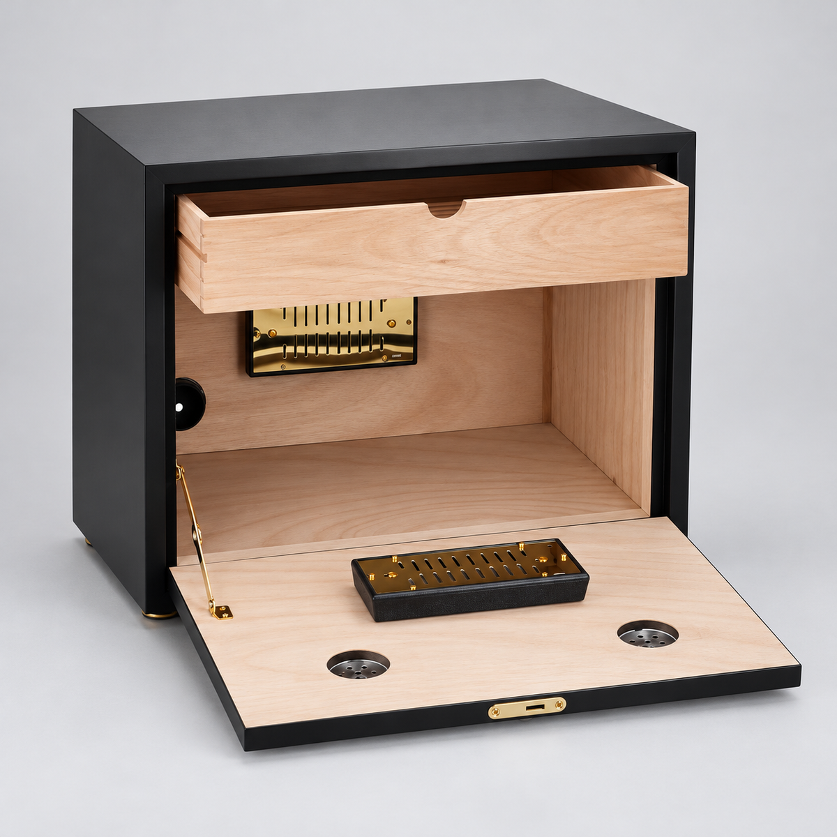 A black wooden humidor with its drawer and front door open, showing a light natural wood interior, brass-toned humidor mechanism, and small black accessory tray on a light gray background.