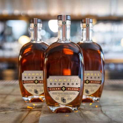 Three bottles of Barrel Bourbon Cigar Blend bourbon whiskey arranged on a bar counter with a blurred bar background.