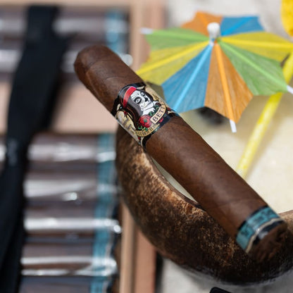 Cigar with a decorative band in front of colorful umbrellas