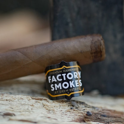 Cigar with Factory Smokes label on a wooden surface