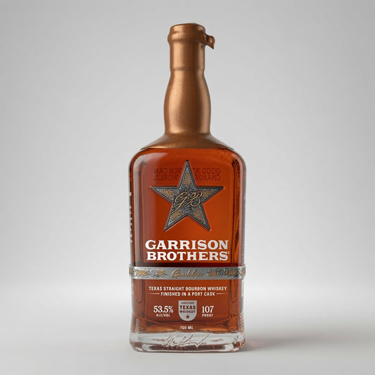 A bottle of Garrison Brothers Texas Straight Bourbon Whiskey on a light gray background. The bottle is filled with amber liquid and features a metallic bronze neck and a label with a silver star logo and white text.