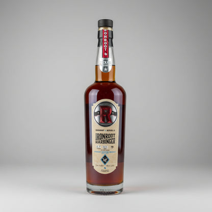 A bottle of Ironroot Harbinger texan whiskey on a white background