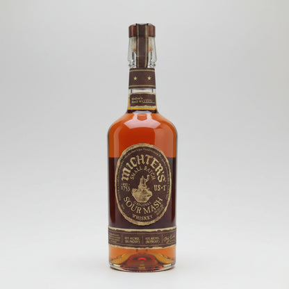 A bottle of Michters Four Mash Whiskey with amber liquid, a dark brown label, and a brown wax seal on a light gray background.