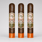 Three dark brown cigars standing upright side by side on a light gray background. Each cigar has a decorative cream, green, and red band label reading 'DH' and 'La Royale 1925', with a bright orange band at the bottom.