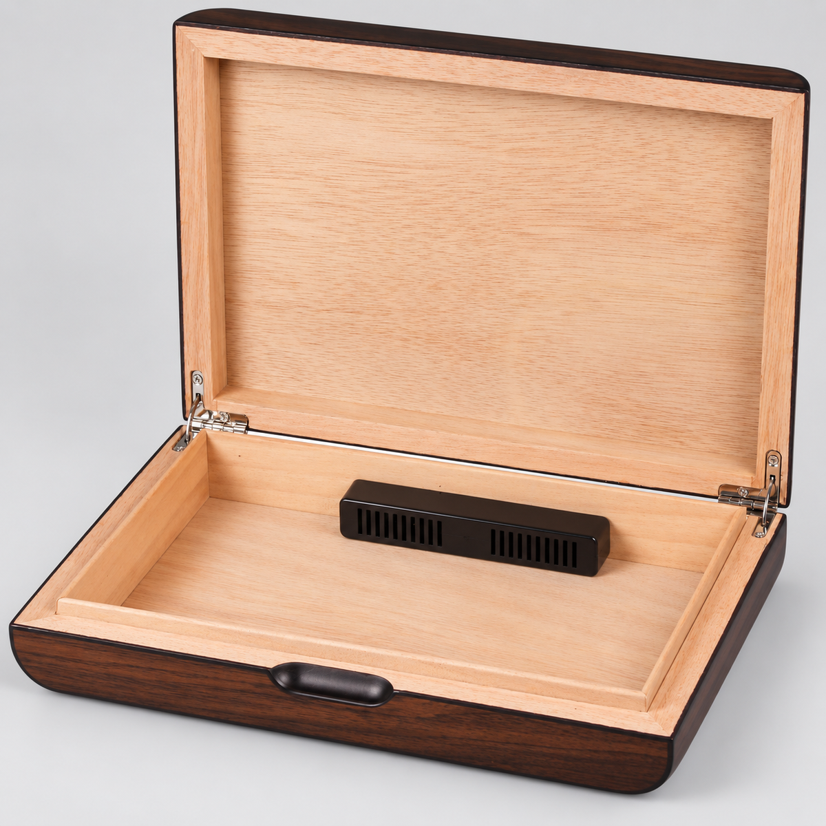 An open wooden humidor box with a light natural wood interior, dark brown wood exterior, and a small black ventilation device resting inside, shown on a light gray background.